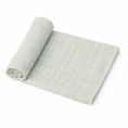 Load image into Gallery viewer, light sage organic muslin baby swaddle blanket rolled on white background
