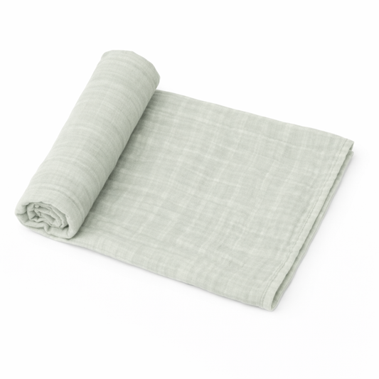 light sage organic muslin baby swaddle blanket rolled on white background