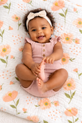 Load image into Gallery viewer, Baby girl in a pink romper sitting on a floral  muslin blanket
